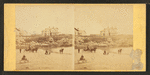Coaches, horseback rider and people on the beach and houses in the distance.