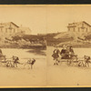 Children in goat cart on beach.