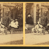 Children in a goat cart in front of house.