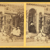 Children in a goat cart in front of house.