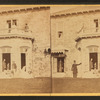 Family posing in front and in the balcony of stone house.