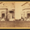 Family posing in front and in the balcony of stone house.