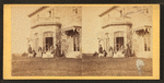 Family posing in front and in the balcony of stone house.