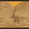 View of boys fishing near bridge.