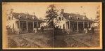 View of a small house with family on porch.