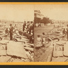 Men and children along battery filled with rubble.
