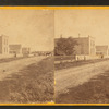 View of an unpaved road with homes.