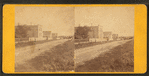 View of an unpaved road with homes.