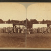 Gideon's Band. Brown's Lake, June 23 to 30, 1875. [Group of women looking at man kneelling, with tents in the background.]