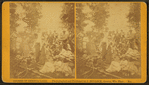 Group around a campfire, woman pouring from a coffee pot.