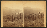 Scene on Bald Mountain? [Men on a mountain wearing packs, one holding a small dog.]