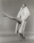 Angela Lansbury wearing fur coat, kicking up her left leg