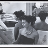 Fashion and costume designer Bonnie Cashin posing with design drawings