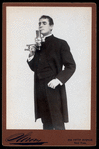 William Gillette, in the role of Sherlock Holmes, lighting a cigarette