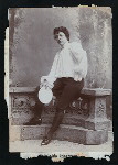 Adelaide Herrmann in costume for her bullet-catching trick and holding the plate used for the bullets