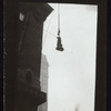 Harry Houdini suspended upside down in a bag from a building roof