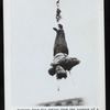 Harry Houdini suspended upside down in a straightjacket
