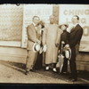 Harry Houdini, Bess Houdini, Ching Ling Foo, Chee Toy, and Tobias Bamberg (aka Okito) outside the Brighton Beach Music Hall, with promotional posters for Foo displayed behind