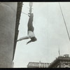 Harry Houdini suspended upside down from a building
