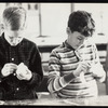 Two children sculpting hand puppet heads from styrofoam