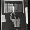 Child measuring the dimensions of a puppet theater set