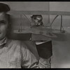 Boy with a hand puppet of a pig in a biplane