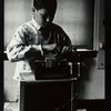 Boy adjusting sound equipment placed atop a puppet theater set