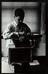 Boy adjusting sound equipment placed atop a puppet theater set