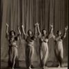 Four dancers with arms raised in gesture of praise
