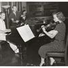 1952 Music Period, woman in polka dot dress playing violin next to two men at piano