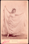 Studio photo of Loie Fuller holding her skirt out.