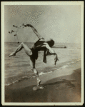 Andreas Pavley  in a Grecian dance, posed on a beach