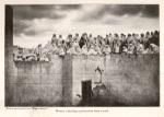 Women watching a procession from a roof