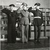 Three Military Men Salute in Front of Bookshelf in U.S.O. Library