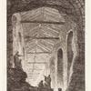 Figures looking inside the large opening in an exterior wall revealing the light-filled interior of a structure with a series of arched entryways
