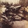 Man seated on rustic bench in rock grotto