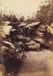 Man seated on rustic bench in rock grotto