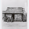 Slaves in front of a cabin