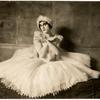 Albert Carroll as Pavlova sitting in white dress and feathered headband
