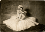 Albert Carroll as Pavlova sitting in white dress and feathered headband