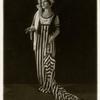 Lily Lubell as Gloria Swanson wearing a stripe dress and holding an umbrella. Island Street Follies. 1925