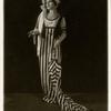 Lily Lubell as Gloria Swanson wearing a stripe dress and holding an umbrella in Island Street Follies