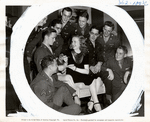 Publicity photo of Deanna Durbin surrounded by servicemen