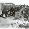 Unidentified men with horses standing on a hillside with "Hollywoodland" sign in background.