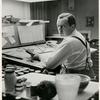 Jo Mielziner sitting at table holding glasses
