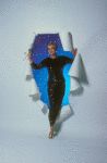 Angela Lansbury in black sequin gown, blue and starry background, holding a long stemmed red rose, stepping through a white paper "portal"