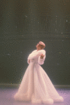 Angela Lansbury live on stage (Mame) in lavish white evening coat, facing the audience (curtain call?), shot from the wings