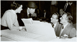 Julie Andrews, Rex Harrison (standing), Alan Jay Lerner, and Frederick Loewe (seated) at white grand piano