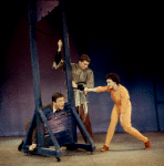 Dick Van Dyke with head in guillotine, unidentified actor, and Chita Rivera in Bye Bye Birdie.