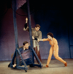 Dick Van Dyke with head in guillotine, unidentified actor, and Chita Rivera in Bye Bye Birdie.